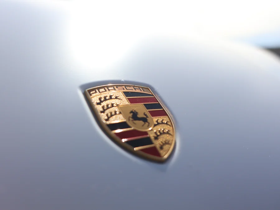 Эмблема Porsche на чистом кузове